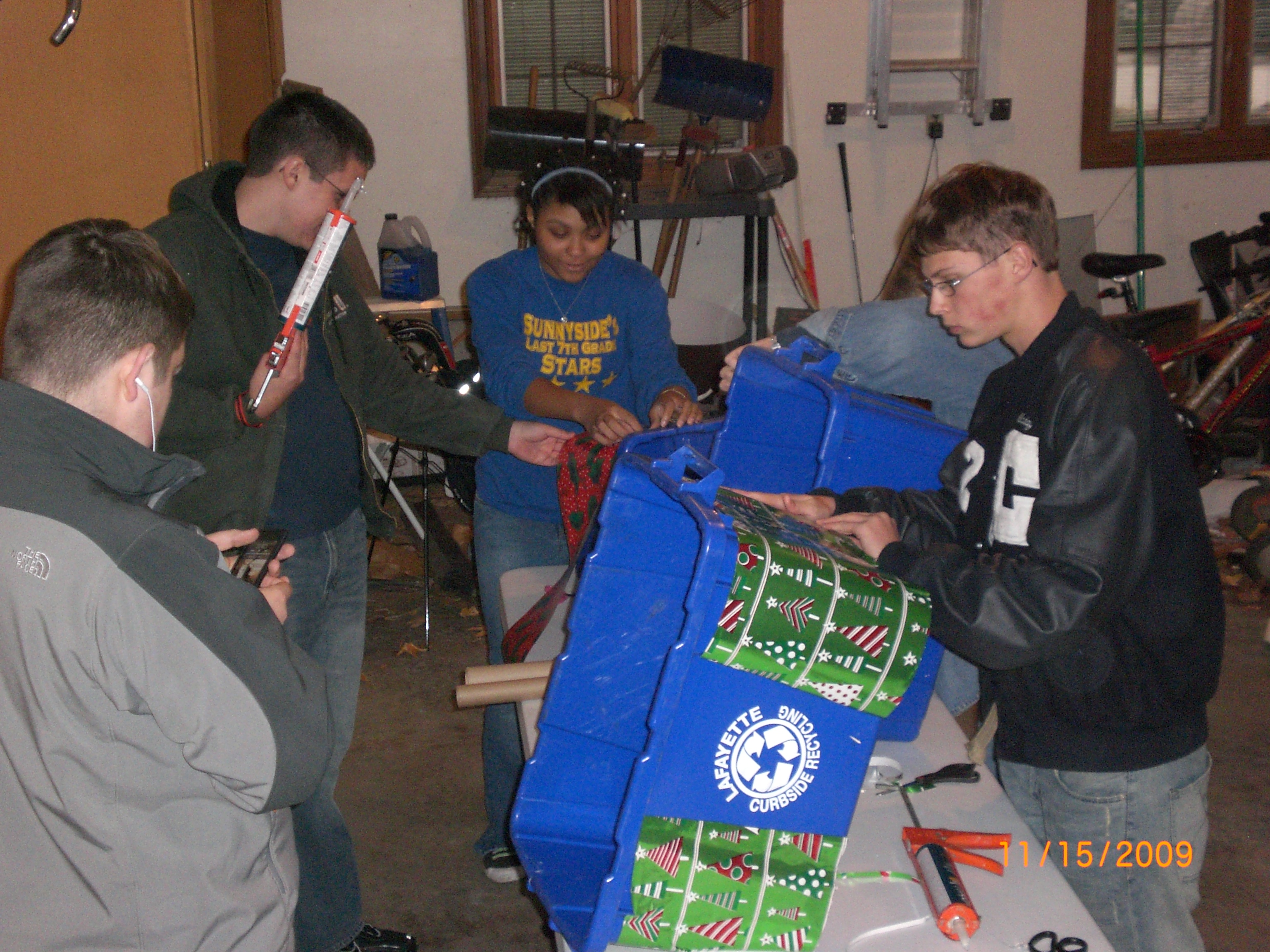 Teenagers preparing for the parade by decorating recycling bins